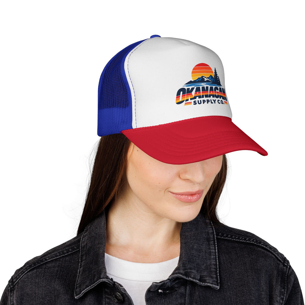 Okanagan Supply Co. Vintage Outdoors trucker hat in blue and red, worn by a model
