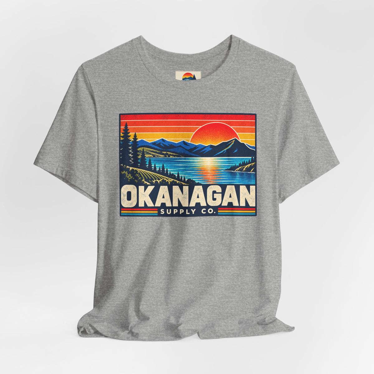 Okanagan Supply Co. Retro Sunset Tee in athletic heather, styled flat view with sunset badge