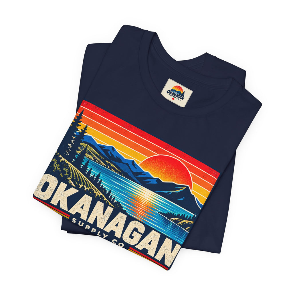 Okanagan Supply Co. Retro Sunset Tee in navy, folded to show the sunset badge print and inside collar label