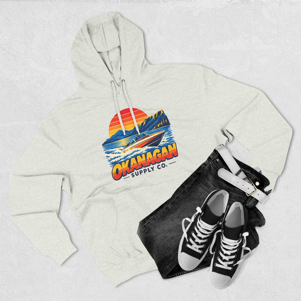 Okanagan Supply Co. Lake Day Speedboat Hoodie in oatmeal heather, flat lay with jeans and sneakers