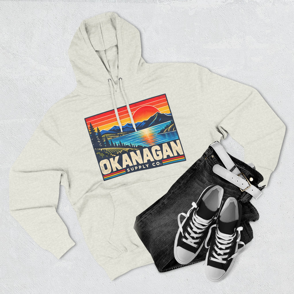 Okanagan Supply Co. Retro Sunset Hoodie in oatmeal heather, flat lay with jeans and sneakers