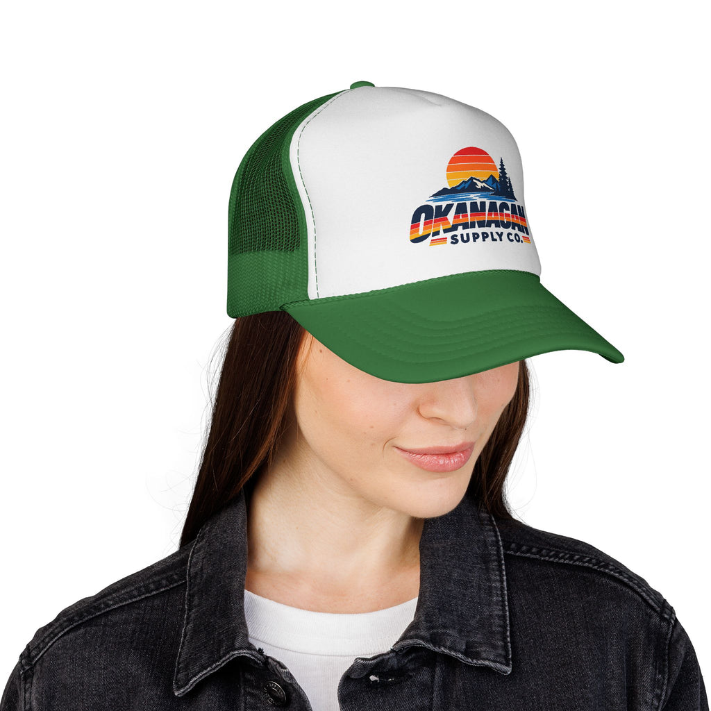Okanagan Supply Co. Vintage Outdoors trucker hat in green, worn by a model