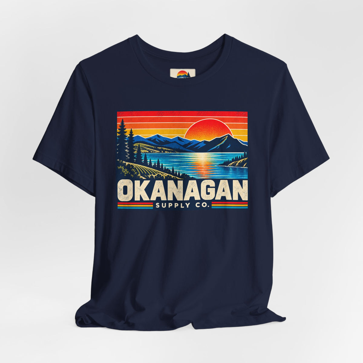 Okanagan Supply Co. Retro Sunset Tee in navy, styled flat view with sunset badge