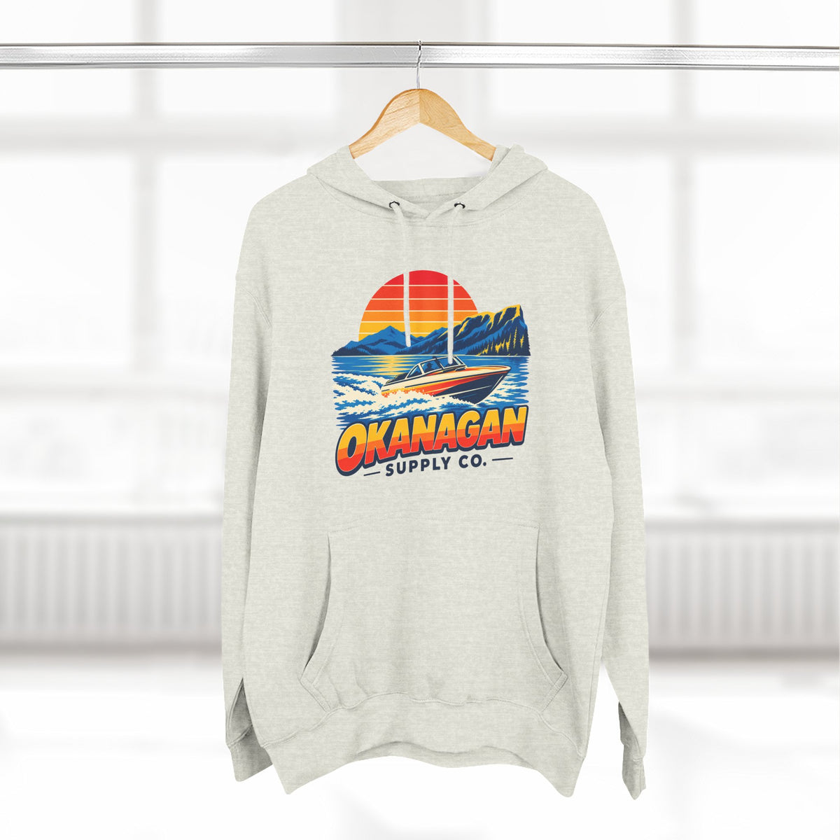Okanagan Supply Co. Lake Day Speedboat Hoodie in oatmeal heather, hanging on a rack