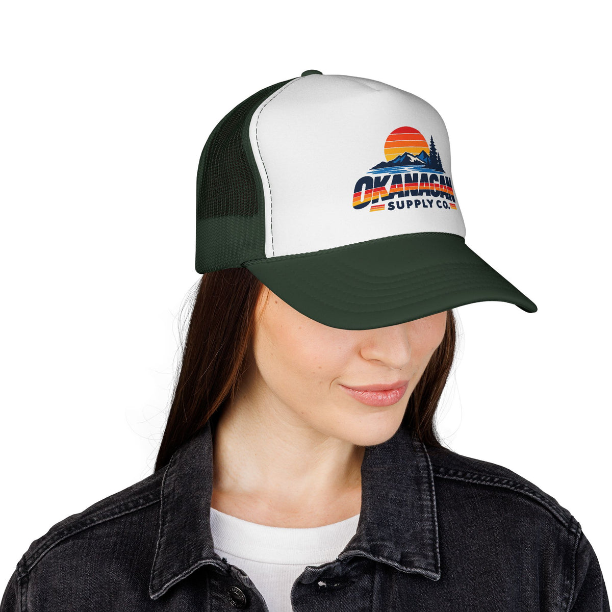 Okanagan Supply Co. Vintage Outdoors trucker hat in dark green, worn by a model