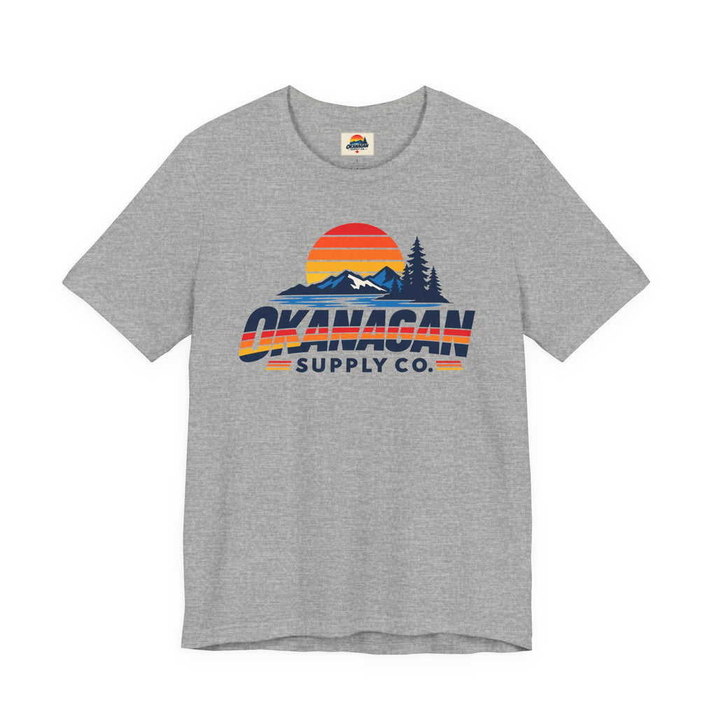 Okanagan Supply Co. Vintage Outdoors Tee in athletic heather, front view with retro sunset, mountain and pine print