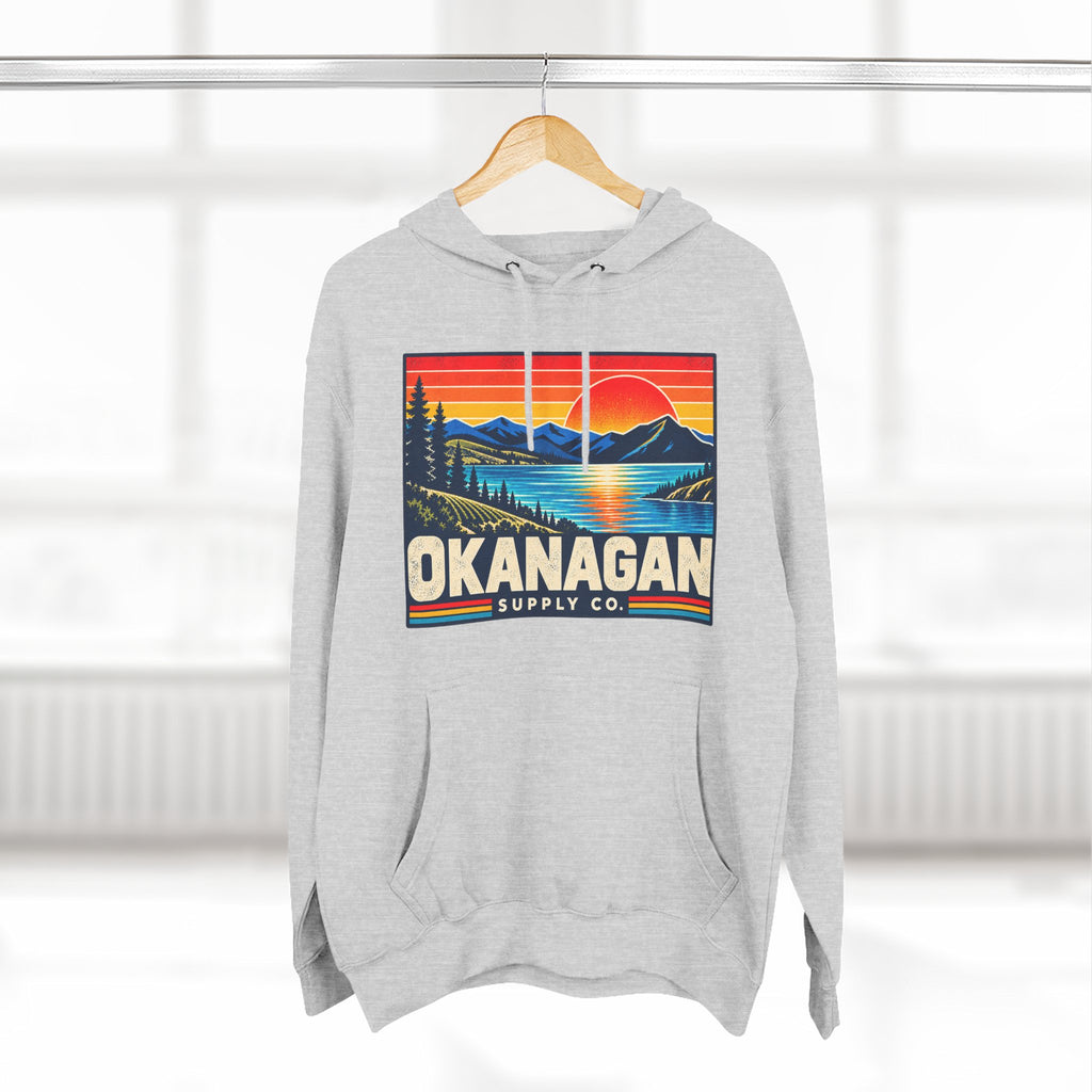 Okanagan Supply Co. Retro Sunset Hoodie in heather grey, hanging on a rack