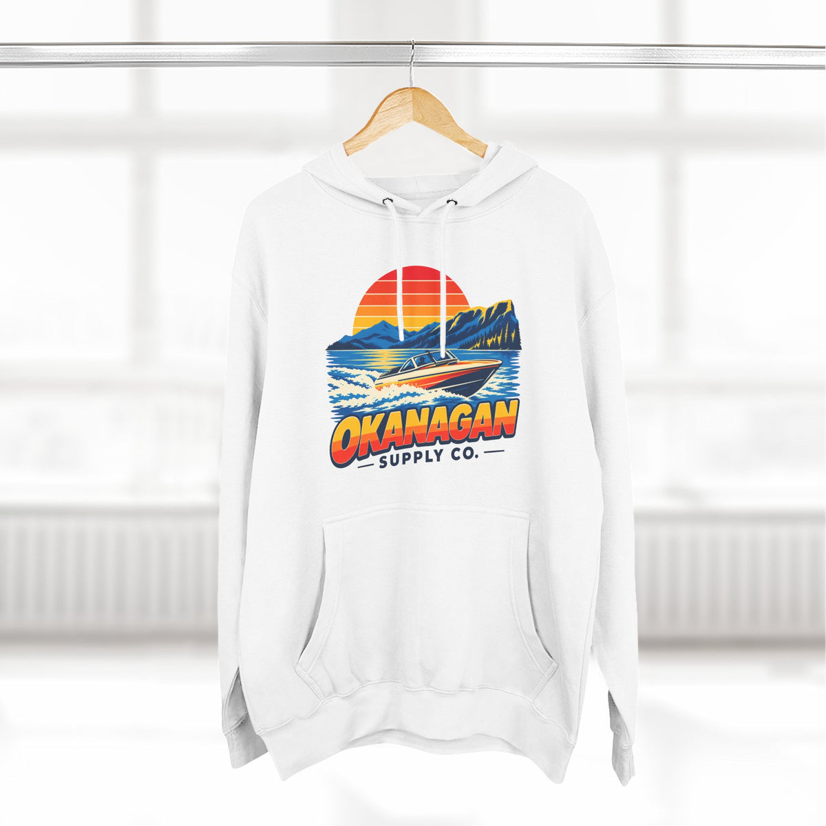 Okanagan Supply Co. Lake Day Speedboat Hoodie in white, hanging on a rack