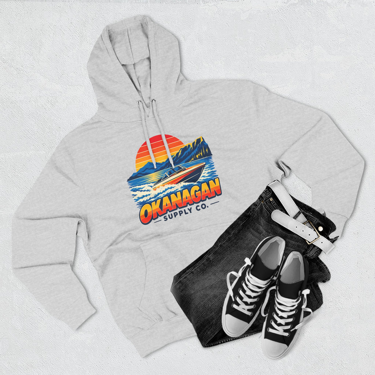 Okanagan Supply Co. Lake Day Speedboat Hoodie in heather grey, flat lay with jeans and sneakers