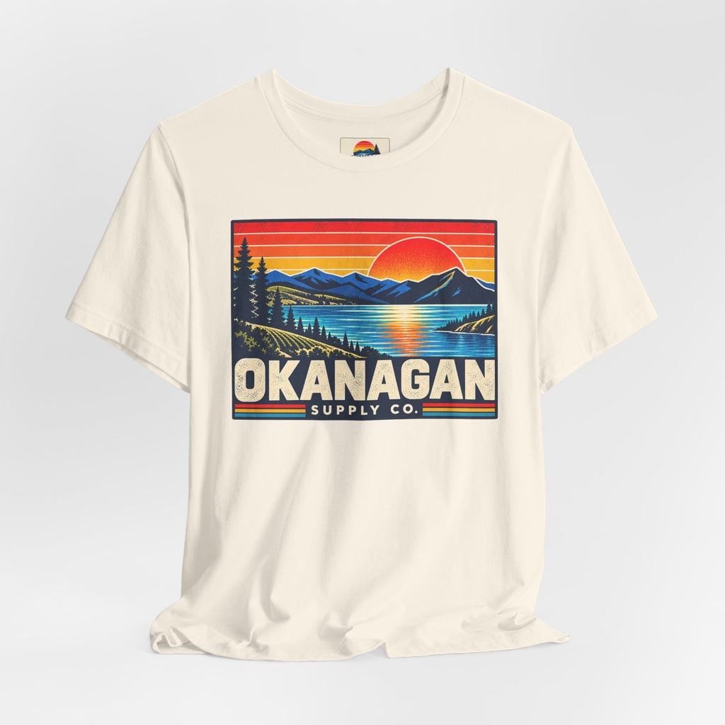 Okanagan Supply Co. Retro Sunset Tee in natural, styled flat view with sunset badge